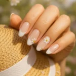 3D floral nails adorned with pearls for elegant French tips