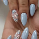 Stylish baby blue nails featuring ombre, French tips, and glitter designs