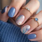 Blue floral nail art with daisy accent for spring gel nails.