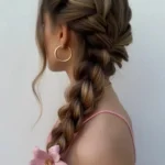 Elegant long hairstyle with a loose side braid and floral accent for 2026.
