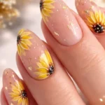 Elegant nude floral nail art with golden sunflower design