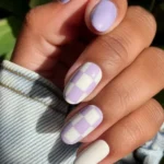 Vibrant neon peach nails featuring miniature heart decals for a stylish nail art design.