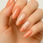 Short acrylic summer nails with pink floral design and peach accents.