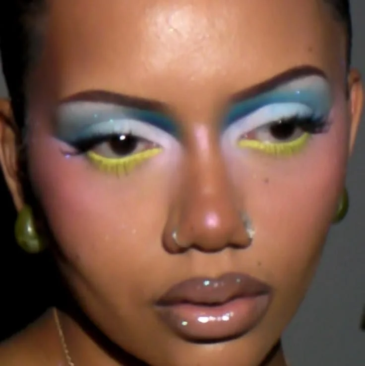 Stunning yellow and blue makeup look with vibrant colors and creative designs.