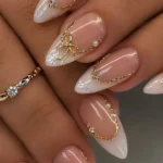 Elegant nude French tip nails with gold bow accents design