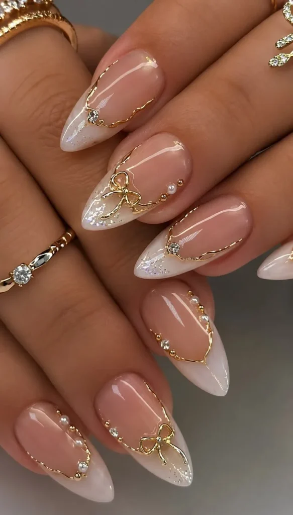 Elegant nude French tip nails with gold bow accents design