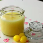 A refreshing lemon drop candle in a stylish holder on a wooden table.