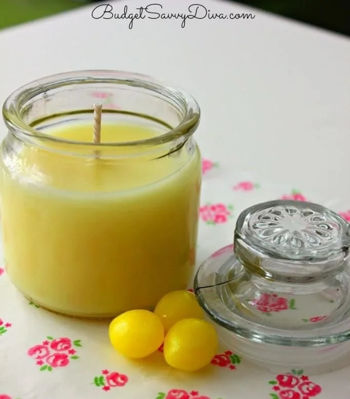 A refreshing lemon drop candle in a stylish holder on a wooden table.