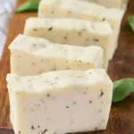 Homemade basil soap with fresh herbs displayed on a rustic background