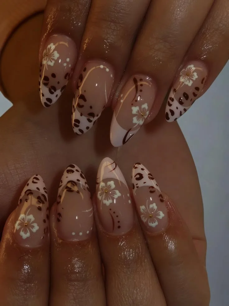 Leopard print press on nails with white floral art, brown spots, and gold accents.