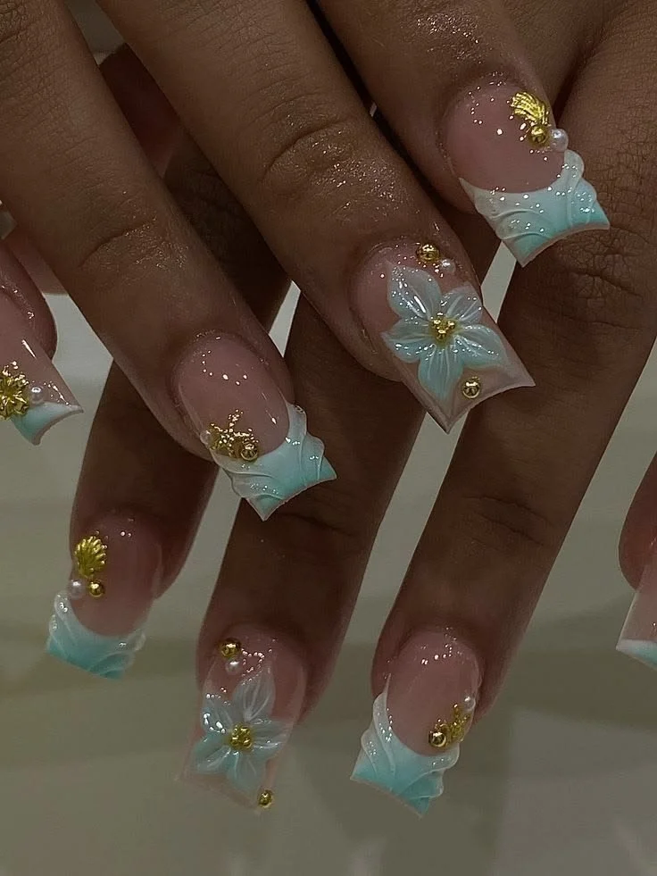 Light blue and gold flower nails with French tips and floral designs for black skin.