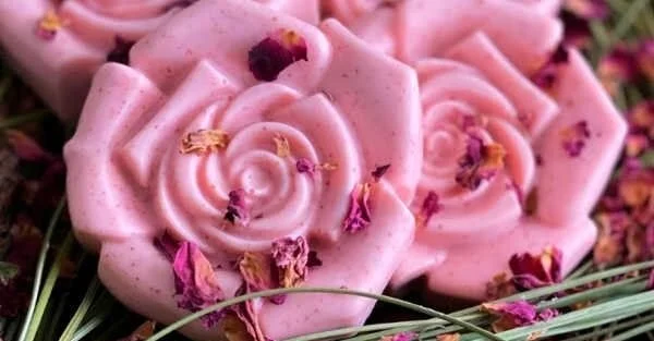 Homemade rose goat milk soap bars arranged on a marble surface