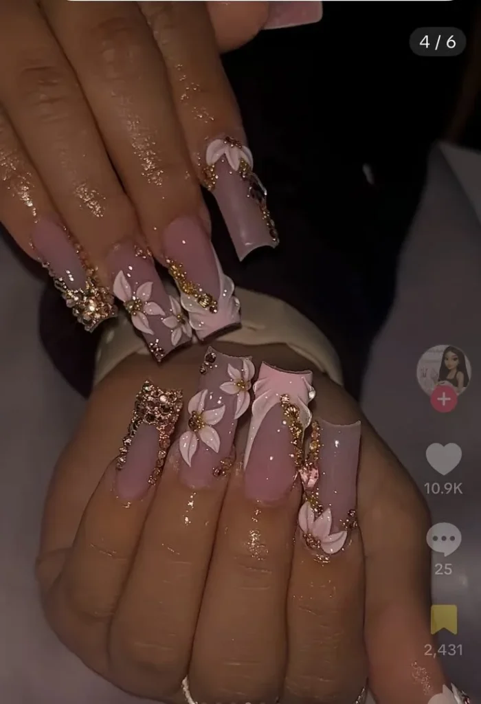 White flower nails with rose gold and brown design featuring gems.