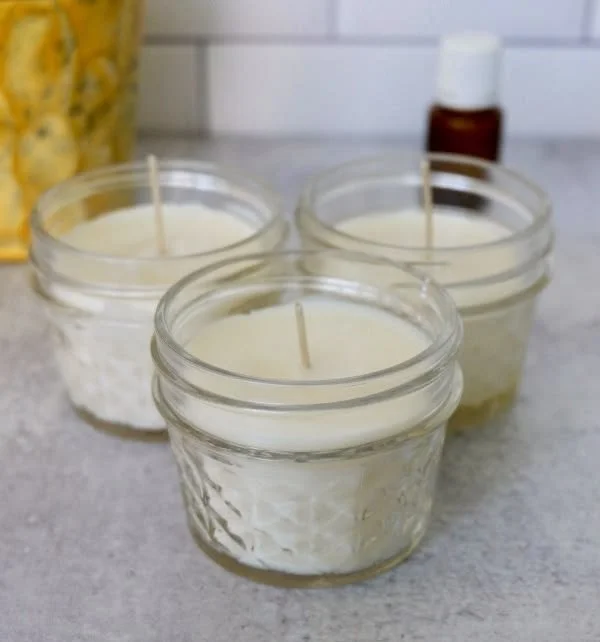 A busy mom crafting a homemade essential oil candle with natural ingredients.