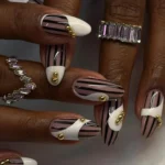 Elegant black white and gold nails design with rhinestones on stiletto acrylics