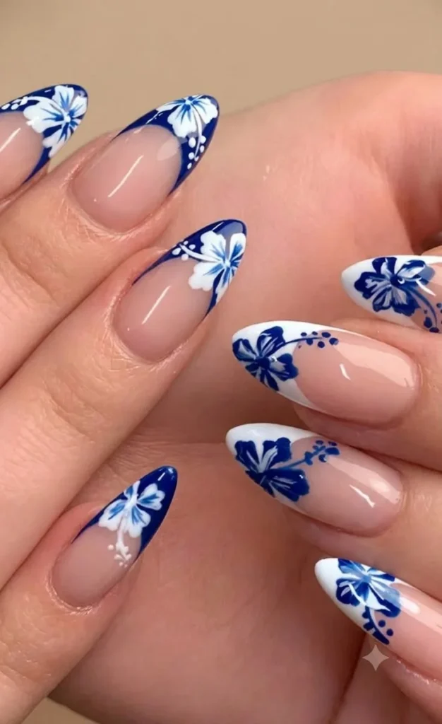 Blue and white hibiscus nail art design featuring trendy French tips
