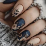 Blue nails with flower design in navy and gold for a stylish fall look.