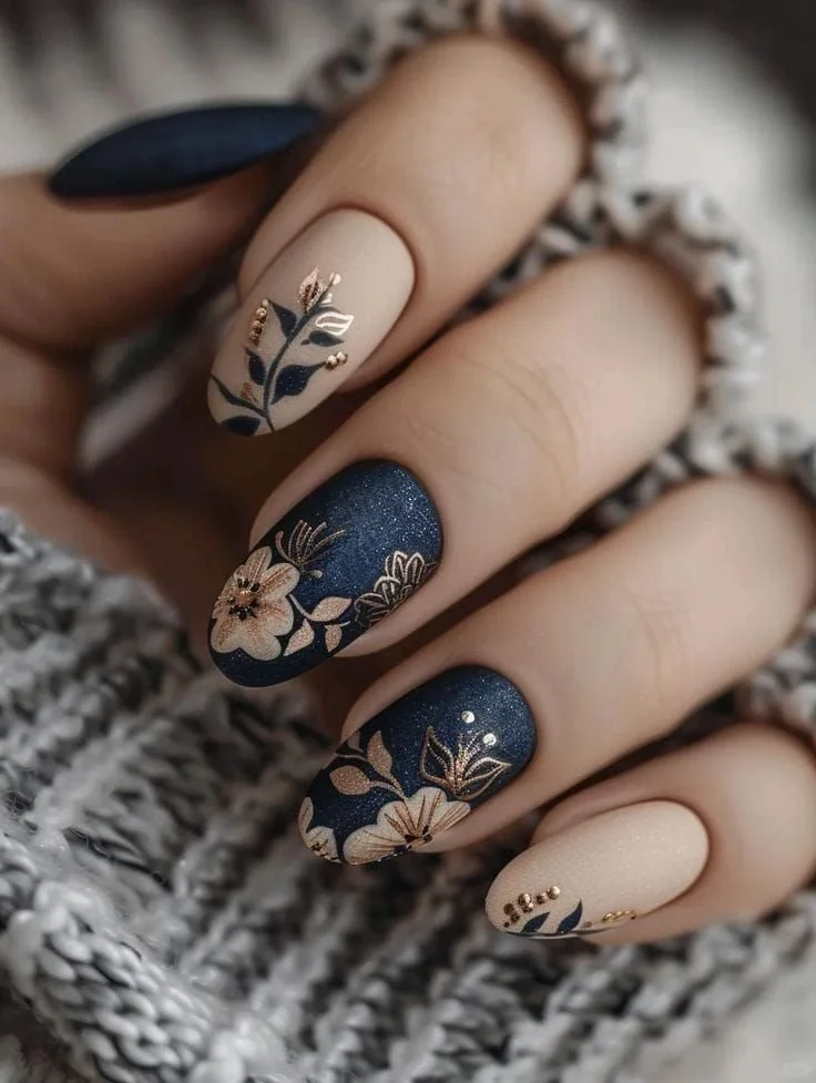 Blue nails with flower design in navy and gold for a stylish fall look.