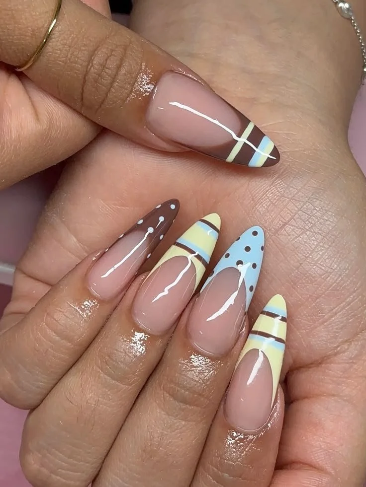 Beautiful yellow almond nails design with brown and blue for a summery vibe.