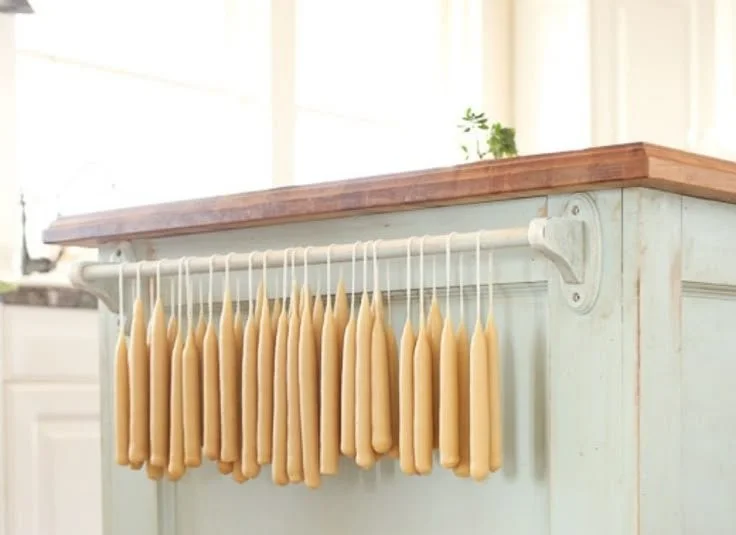 Handmade beeswax taper candles made through candle dipping technique.