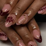 Elegant burgundy nails design with gold accents for summer nail art.