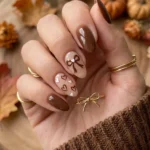 Cottagecore brown nails decorated with bows and hearts for autumn style