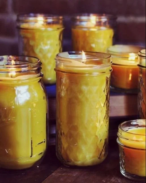 Homemade beeswax candles displayed with natural decorations and scents.