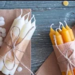Handmade DIY candles on a rustic table for homestead survival