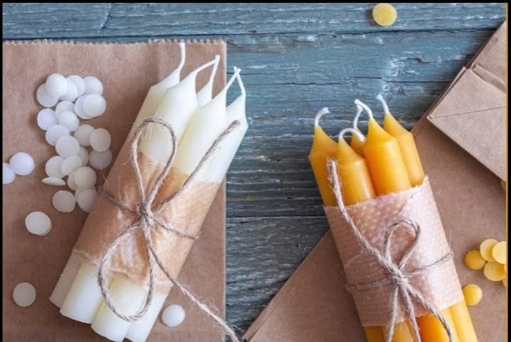 Handmade DIY candles on a rustic table for homestead survival