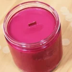 DIY scented candles made from soy wax with wooden wicks and decorative elements.