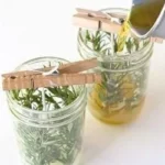 DIY herb candles with rosemary in cozy mason jars for home decor.