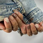 Fall 2024 manicure trends showcasing brown and white nails with simple designs.