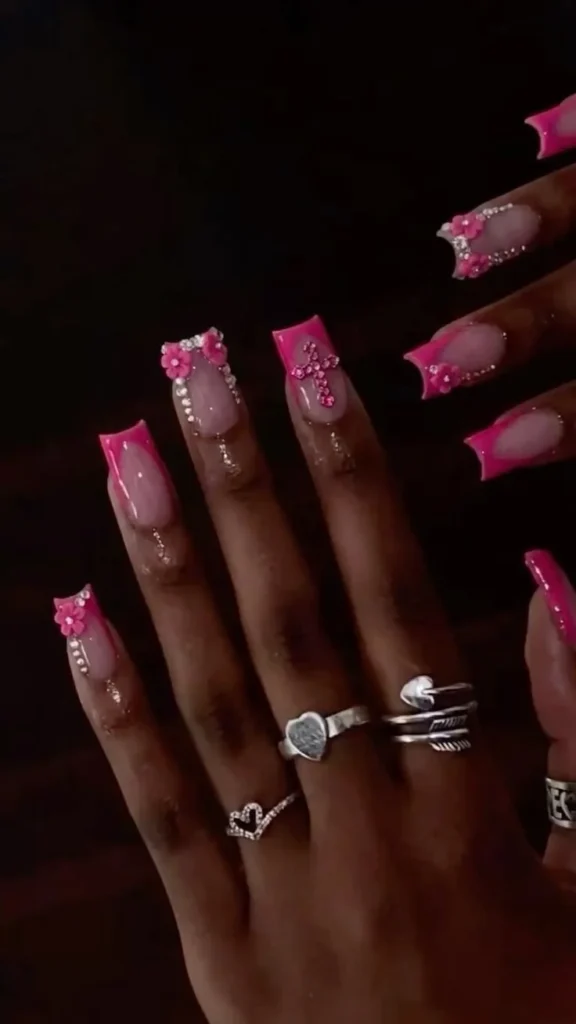 Hot pink nails featuring bow charms and French tip designs for a chic manicure.