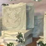Homemade peppermint eucalyptus soap bars stacked on a wooden surface