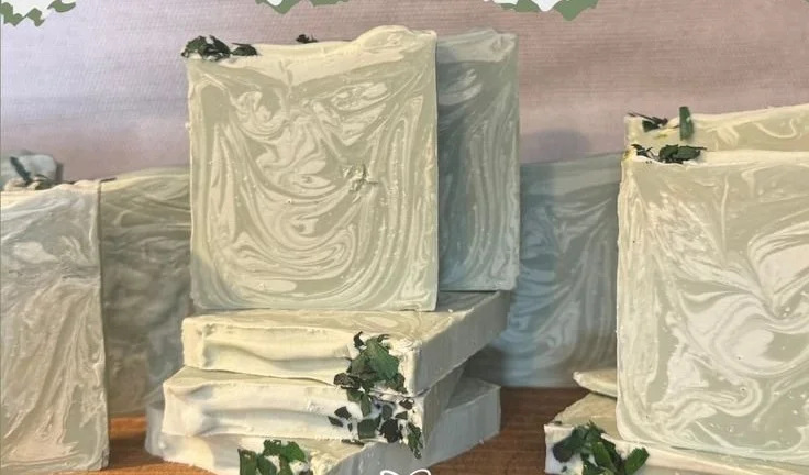 Homemade peppermint eucalyptus soap bars stacked on a wooden surface