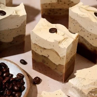 Homemade Latte Cold Process Soap on a wooden counter with coffee beans.