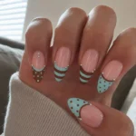 Nails featuring a stylish striped and dots design for a chic look