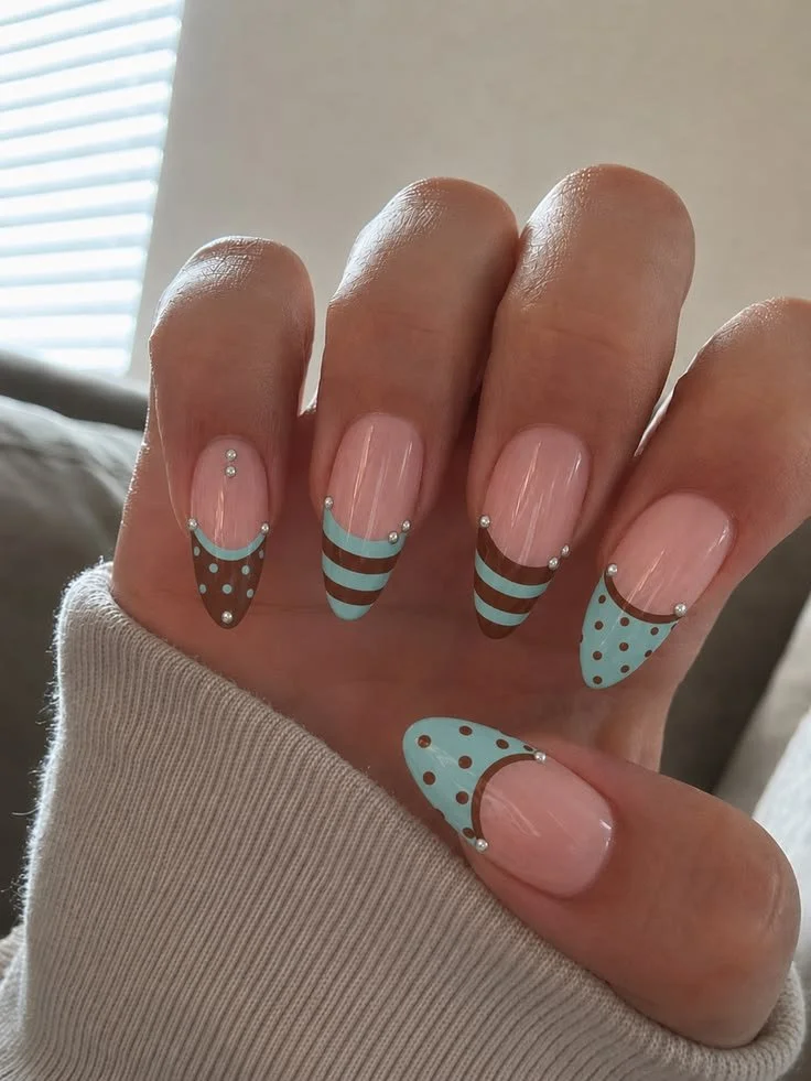 Nails featuring a stylish striped and dots design for a chic look