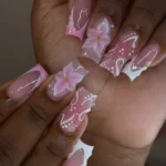 Pink French tip nails with flower designs in a DIY tutorial for beginners