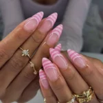 Stylish pink french tip nails with stripes design for elegant nail art.