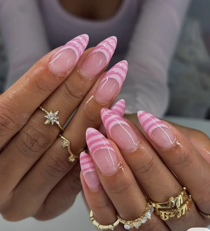 Stylish pink french tip nails with stripes design for elegant nail art.