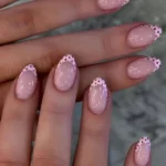 Pink nails design featuring dot French tips and polka dot acrylic nails.