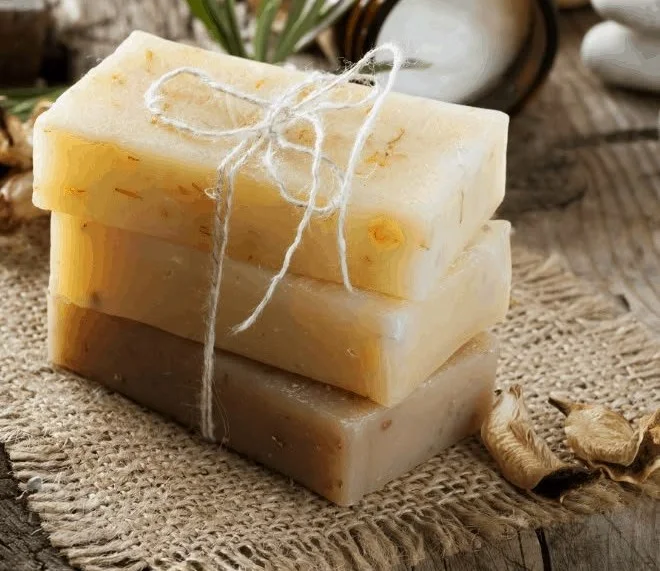 Homemade oatmeal and honey soap bars on a wooden surface