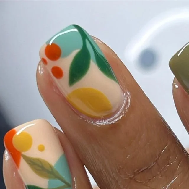 Colorful gel manicure showcasing fall nail designs with fruits and flowers for 2026.