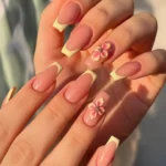 Yellow French tip nails with 3D flowers for vibrant summer nail art