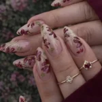 Autumn almond nails featuring a delicate fall flower design