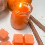 Homemade pumpkin spice candle glowing warmly in an autumn setting