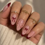 Beautiful pink and burgundy nails with cute bow and floral designs for 2026.