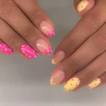 Pink and yellow polka dot press on nails in short almond French tip style