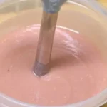 Cold process salt bar soap in loaf molds with ingredients and tools for soap making.